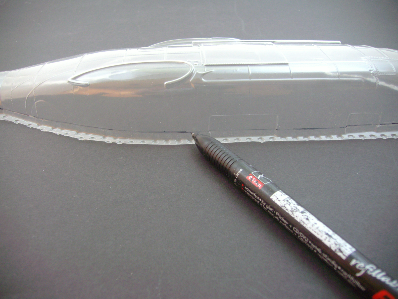 Bild 05: Die Rumpfhälfte wird auf eine glatte Fläche aufgelegt und mit einem wasserfesten Stift ringsum eine Linie gezogen. Tiefziehteile habe meist unten drunter eine Distanzschicht, damit das Teil glatt enden kann und nicht rund.