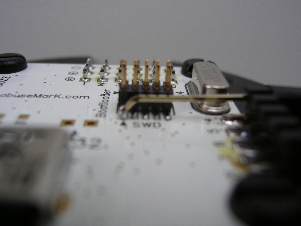 Da auf dem Rev4 Board kein separater 3V3 Anschluss vorhanden ist wird die Versorgungsspannung nun vom SWD-Connector abgegriffen. Ist der alte Pin (vorher an Bootloader Pad), nur vorsichtig zurechtgebogen. Detailansicht von der Seite.
