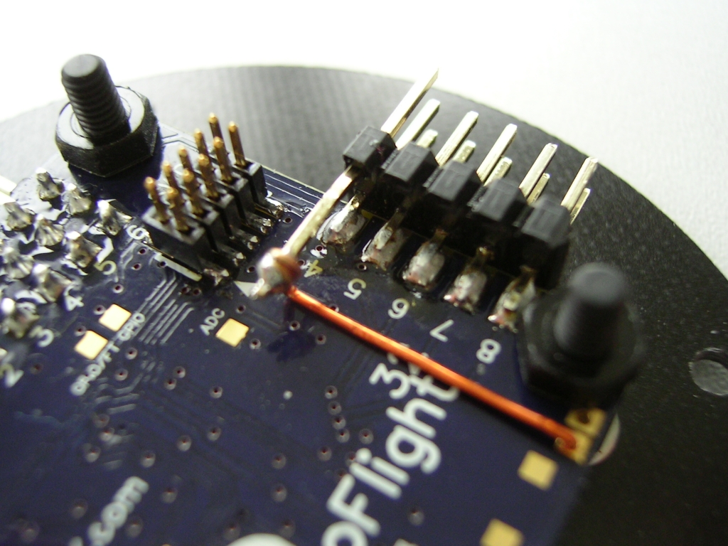 Auf der Rev5 kommen die 3V3 für den Spektrum Sat nun von dem 3V3 Anschluss. Ich habe hier Kupferlackdraht (!) verwendet. Der Pin ist der mittlere aus eine 3-reihigen 90° Stiftleiste; er wurde lediglich vorsichtig (!) begradigt.