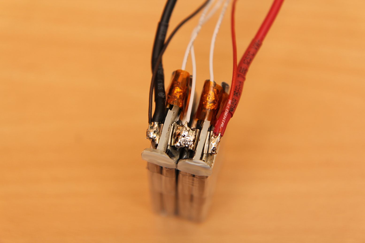 Schritt 6 und 7: Die zwei Lipos nebeneinander ausrichten und zusammenlöten, dabei lieber ein paar Sekunden zu lange als zu kurz anheizen und mit<br />Lötzinn nicht sparen. Erstens fließt hier der ganze Strom drüber und zweitens liegt das Modell am Boden, wenn diese Verbindung sich löst.<br />Die übrigen Balancerkabel anlöten. Und schon ist die Löterei fertig.