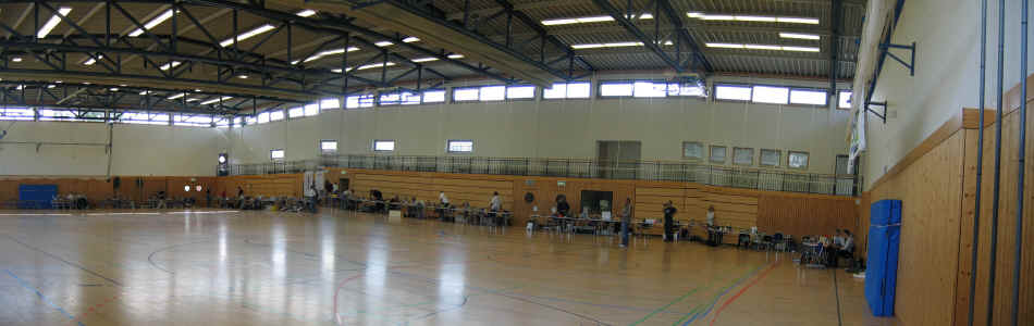 mal einen Einblick in die Halle, eine große Runde von vollgestellten Tischen
