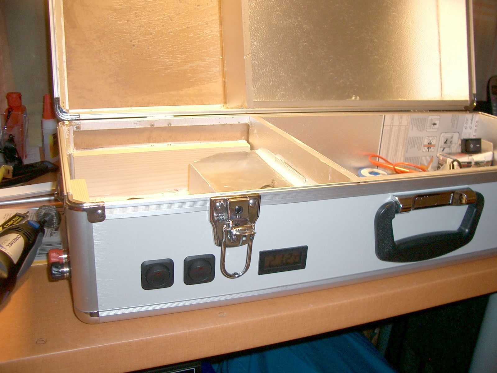 Frontansicht, Kfz-Wippschalter von Conrad mit LED. Links für die Ladegeräte, Rechts für den Heizkreis. Das Thermometer ist von Voltcraft (auch von Conrad). Neben die Anschlüsse links kommt noch eine Sicherung für den gesamten Koffer - wahrscheinlich ne normale Feinsicherung, leider hab ich noch keinen Sicherungsautomaten mit entsprechend hohem Auslösestrom gefunden.
